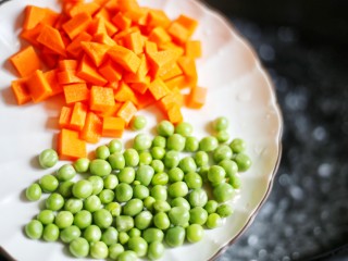 4、下饭神器小炒藕丁,中烧开水,放入青豆和胡萝卜。