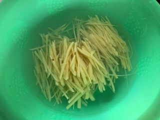 4、蒜香酸辣土豆丝,一边切一边将切好的土豆丝放入清水里面