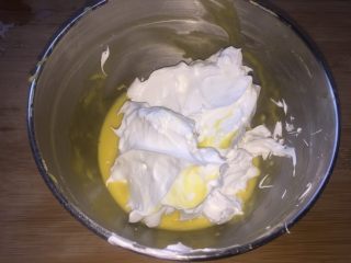 7、一口肉松小贝+#美食拔草大作战#,三分之一蛋白霜放进面糊里,用刮刀翻拌均匀。