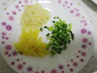 4、白切鸡,煮鸡期间，将葱姜蒜切细。准备一盆凉开水备用。