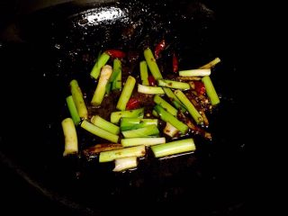 8、腊肠炒香干,放入干辣椒段、姜丝和青蒜白爆香。