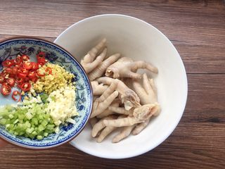 14、凉拌麻辣鸡爪,把待用的鸡爪放大碗中，姜蒜小米辣，香菜一起倒入鸡爪碗里。