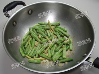 5、豆角焖面,加入豆角，用小火炒至表皮变色。