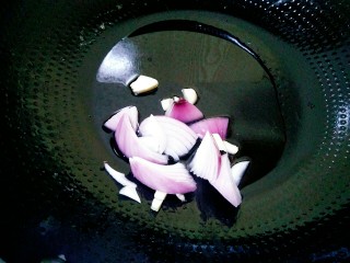7、手撕包菜,锅中放油，把洋葱和蒜粒倒进去翻炒