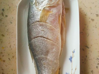 2、清蒸黄花鱼,黄花鱼去鱼鳞,洗干净,往鱼表面斜切三刀,两面都要切