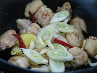 5、鸡翅腐竹烧土豆,然后放入葱花、姜片、蒜片和红干椒，翻炒出香味