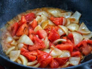 7、西红柿土豆炖牛肉,接着放入一半的番茄和洋葱，小火将番茄炒出汤汁。