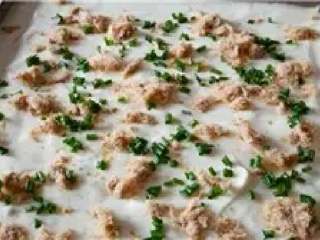 8、肉松卷,倒入铺了油布的金盘，震几下后在表面均匀撒上肉松和香葱