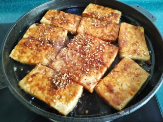 14、铁板豆腐,两面都刷上酱料后，撒上调好的芝麻辣椒粉。