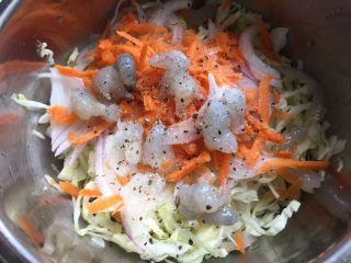 7、大阪烧,把切好的蔬菜丝和虾仁放入盆里，加一点点盐和黑胡椒碎