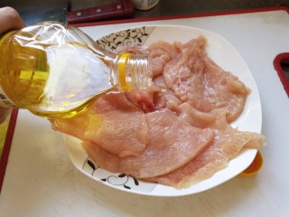 3、烤箱香酥大鸡排,放入一瓶盖量的油用手抓匀