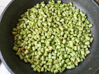 8、肉末豆角,下入豆角煸炒。