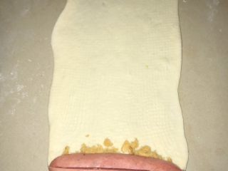 17、葱香芝士香肠面包,桌面撒少许面粉，光滑面朝下，防卷起时粘桌面。然后将面团擀开，擀长。可以放上肉松，热狗，或者培根、火腿肠。