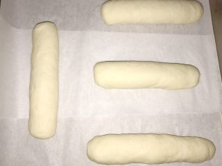 19、葱香芝士香肠面包,卷好后两头捏紧，底部收好口。放入烤箱，二次发酵，发至两倍大。38度左右温度。（大家可以买纸托～放纸托里面更好）