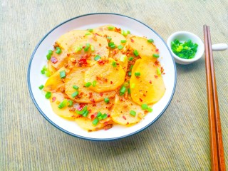 11、爽口酸辣土豆片,出锅盛盘,撒上葱花即可。