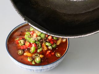 17、水煮鱼片,撒上干辣椒、花椒,烧少许油至微微冒烟,在辣椒上,炸出香味即可。