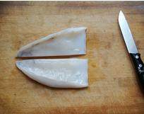 3、生炒墨鱼,先将墨魚躯干纵向分割成5cm宽的长片，内侧向上横放在砧板上