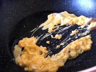 4、早餐 鸡蛋火腿三明治,将鸡蛋在碗中加盐打散放入锅中快速炒散