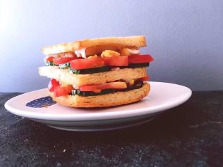 12、早餐 鸡蛋火腿三明治,将沙拉酱那一面盖在火腿上，压紧，外面一层按刚刚的顺序摆好。压紧