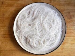 4、蒜蓉粉丝开背虾,将泡软的粉丝沥水后铺在盘底。