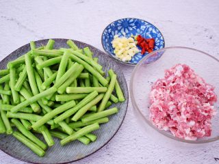 2、干煸豆角,豆角去掉头尾，再切成寸段，洗净后控干水分备用，猪肉剁成末备用，蒜切末，干红辣椒斜切圈