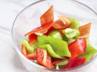 2、绿色美食+豆豉香干回锅肉,青椒也同样切菱形片,装碗备用。