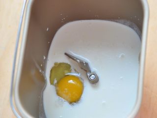 2、蛋蔬汉堡,将牛奶和鸡蛋放入面包桶中,再放入糖和盐。