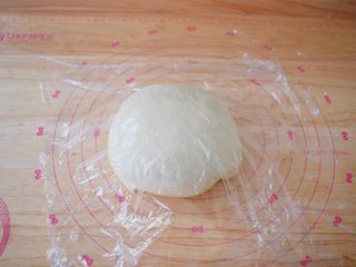 6、自制健康油条,把发酵好的面团取出，揉几下排气，盖上保鲜膜醒发20分钟