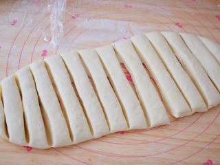 8、自制健康油条,用锋利的刀切成约2厘米的条状，再将切好的面团盖上保鲜膜松弛几分钟，这样做出来的油条更松软