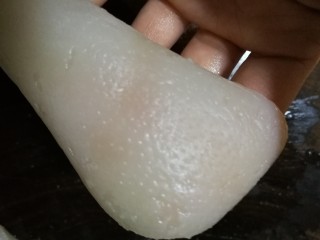 4、豆皮猪皮冻,肉皮里层的油脂刮干净后，就该检查外层的肉皮上有没有猪毛了。手摸眼瞧不放过一根猪毛，找到后用镊子拔除。