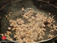 8、咸鱼茄子煲,锅中热油,下猪肉碎和咸鱼,用中火将其煸至酥脆。