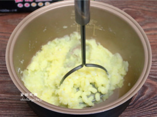 6、凤尾虾球,土豆片倒入高脚盆里，调入2克盐、用压泥器把土豆压烂，没有压泥器就直接用叉子或用手捻碎。