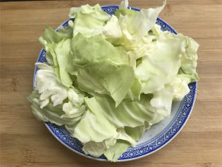 2、炝炒手撕包菜,卷心菜剥去外面的老叶，把里面的叶子一张张剥开后清洗干净，然后再用手撕成小片，中间的硬梗不要。