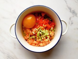 3、卷心菜三文鱼米饼,将蔬菜、三文鱼和鸡蛋放入碗内搅拌均匀