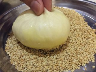 7、黑椒鸡肉汉堡,将刷蛋黄液的一面圴匀地沾上熟白芝麻