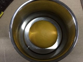 5、南瓜汉堡包,程序结束后,取出面团,揉圆后放置干净的容器内发酵