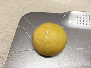 12、南瓜汉堡包,对向的两根棉线提起在面团顶部中间打结