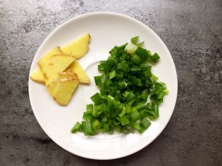 3、水煮肉片,将生姜切片,小葱切小段备用。
