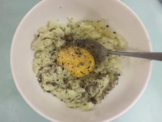 5、花菜底迷你披萨,把挤干的花菜泥放入碗中加鸡蛋、蒜盐、黑胡椒碎、干罗勒叶、橄榄油拌匀