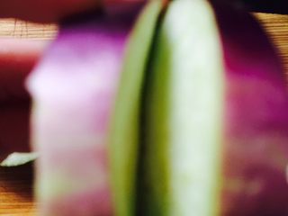 11、鱼香茄饼,将茄子切成稍厚的圆片，需要多少个茄饼就切几片，将切好的茄子圆片中间再划一刀不要划穿，底部留点不要划破