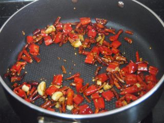 11、辣子鸡,再倒入干辣椒段和花椒翻炒出香气