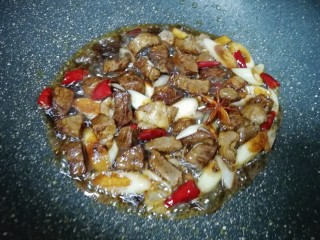 8、土豆烧牛肉,加入两勺红烧酱油和一勺料酒翻炒均匀。