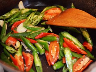 8、辣椒炒荷包蛋,放入辣椒翻炒片刻。