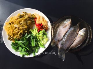 1、酸菜烧鲫鱼,准备材料，将鲫鱼去鳞洗净抹上料酒腌制一会儿。配菜切成如图所示。