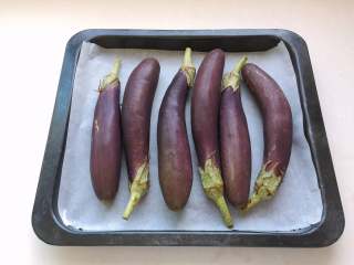 2、油浸蟹味菇拌烤茄子,茄子排入铺了油纸的烤盘中