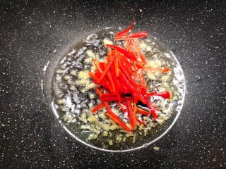 4、豆芽炒韭菜,锅里放入适量油烧热，放入姜末炒香，再放入红椒丝炒至断生。