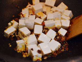 17、正宗地道的麻婆豆腐,放入豆腐，轻轻晃动炒锅。