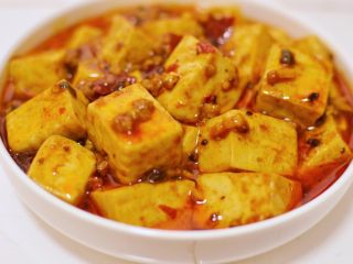 23、正宗地道的麻婆豆腐,盛入盘中之后，淋上花椒油和辣椒油。