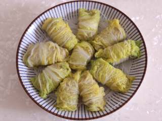 8、娃娃菜卷肉,将卷好的娃娃菜肉卷摆在粉丝上。