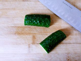 6、黄瓜圣女果鸡蛋沙拉,开始制作盘饰，取一截黄瓜，对半切开。